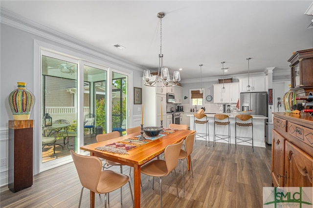 dining space featuring crown molding, visible vents, dark wood-style floors, and a wealth of natural light