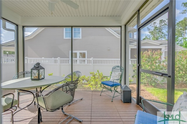 sunroom / solarium featuring a ceiling fan, outdoor dining area, and a wealth of natural light