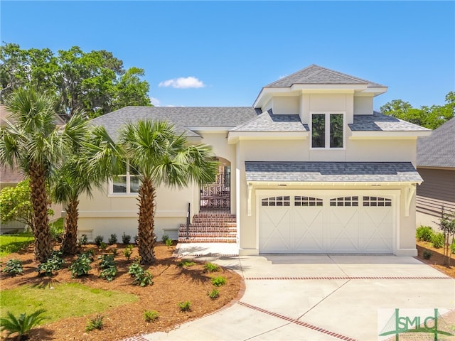view of front facade featuring stucco siding, stairs, a shingled roof, concrete driveway, and an attached garage