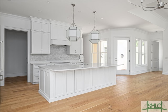 kitchen featuring light countertops, ornamental molding, and light wood-style flooring