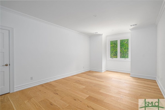 empty room with baseboards, ornamental molding, light wood-type flooring, and visible vents