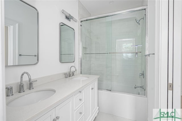 bathroom with double vanity, a sink, and bath / shower combo with glass door
