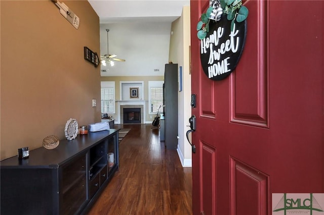 1212 Peacock Trl, Hinesville, GA 31313 - entryway featuring ceiling fan, a tiled fireplace, dark wood finished floors, baseboards, and a high ceiling