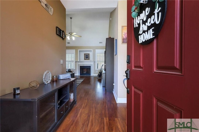 1212 Peacock Trl, Hinesville, GA 31313 - entryway featuring a towering ceiling, baseboards, ceiling fan, dark wood-style floors, and a tile fireplace
