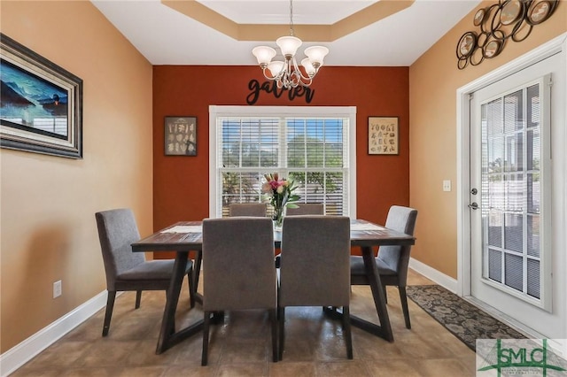 1212 Peacock Trl, Hinesville, GA 31313 - dining space with baseboards, a tray ceiling, and a notable chandelier