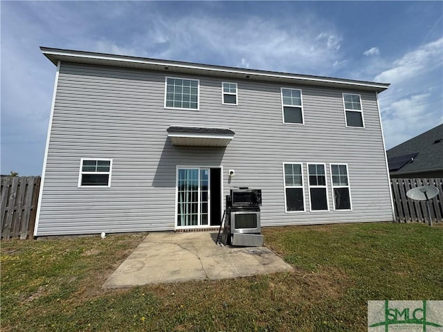 back of house featuring fence, a patio, and a lawn