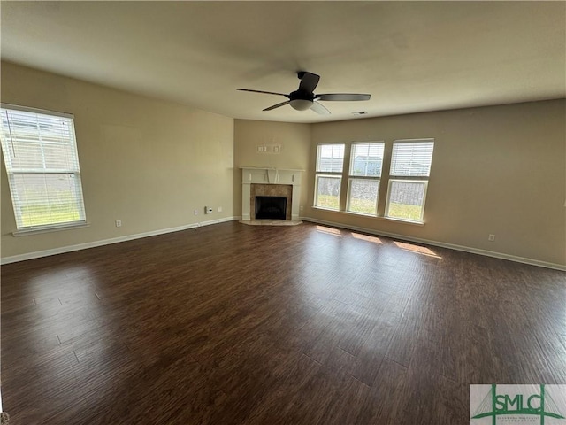 unfurnished living room featuring a ceiling fan, baseboards, and dark wood-style floors