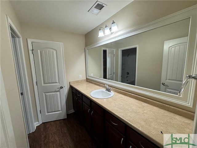 bathroom with visible vents, wood finished floors, and vanity