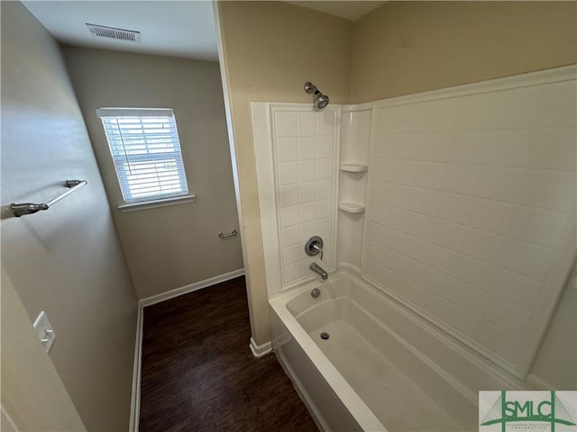 bathroom featuring baseboards, bathtub / shower combination, wood finished floors, and visible vents