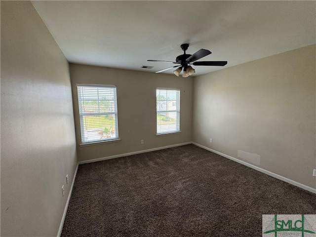 unfurnished room featuring visible vents, a ceiling fan, baseboards, and dark carpet