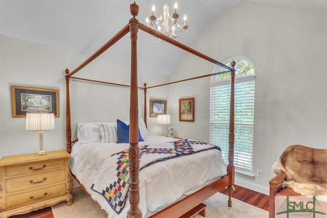 bedroom with an inviting chandelier, baseboards, vaulted ceiling, and wood finished floors