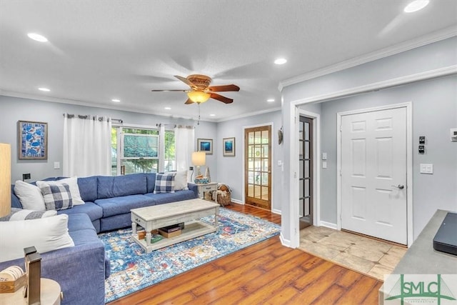 living room featuring crown molding, light wood-style floors, baseboards, recessed lighting, and a ceiling fan