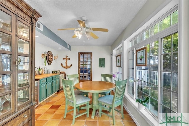 dining room featuring visible vents, a textured ceiling, ceiling fan, and light tile patterned floors