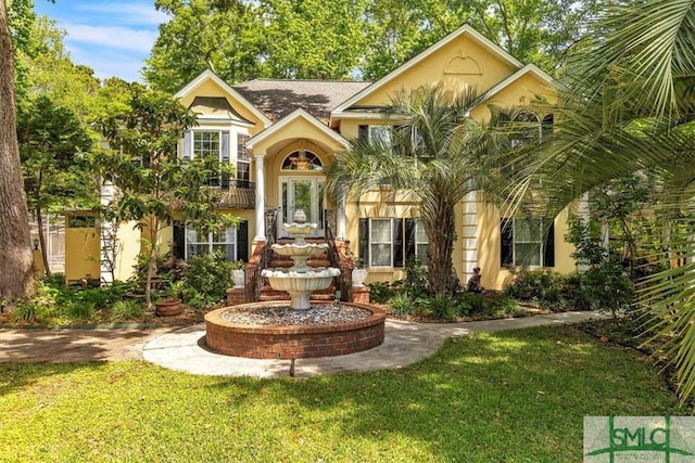 bi-level home with stucco siding and a front yard