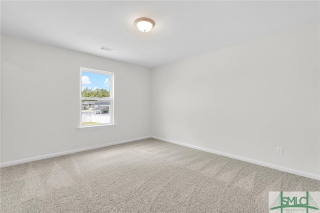 carpeted spare room featuring baseboards and visible vents