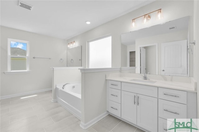 full bath featuring baseboards, vanity, a bath, and visible vents