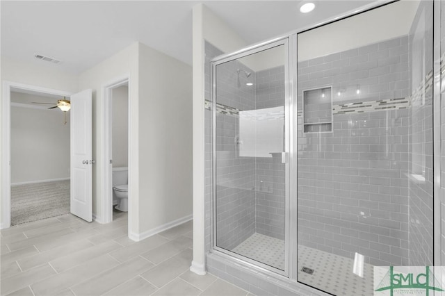 full bathroom with ceiling fan, toilet, baseboards, a shower stall, and visible vents