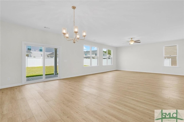 unfurnished living room featuring light wood-style floors, baseboards, ceiling fan with notable chandelier, and visible vents