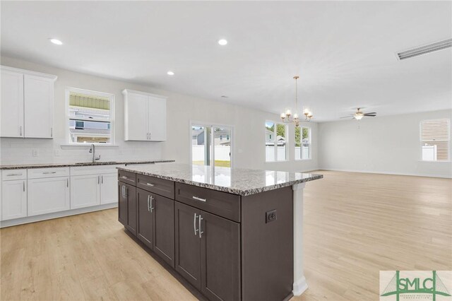 kitchen featuring light wood-style floors, white cabinets, and a sink
