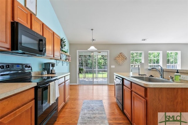 76 Hamilton Grove Dr, Pooler, GA 31322 - kitchen featuring a sink, light wood-style floors, light countertops, brown cabinetry, and black appliances