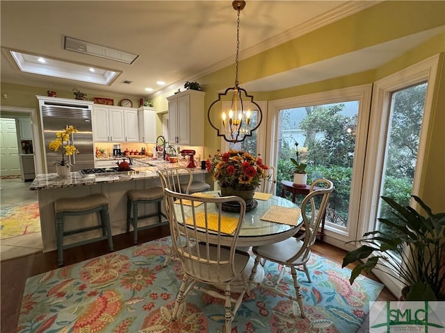 dining space featuring a chandelier, wood finished floors, ornamental molding, and recessed lighting
