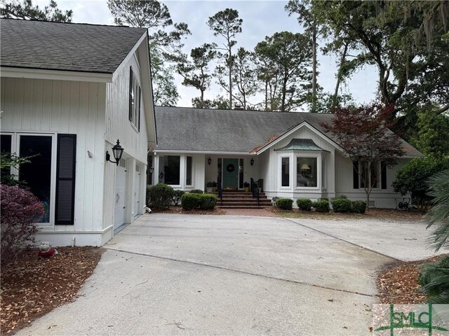 view of front of property with driveway and a shingled roof