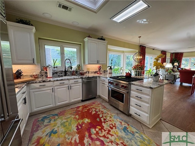 31 Sweetgum Xing, Savannah, GA 31411 - kitchen with appliances with stainless steel finishes, crown molding, backsplash, white cabinetry, and light tile patterned flooring