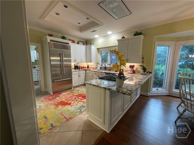 31 Sweetgum Xing, Savannah, GA 31411 - kitchen with appliances with stainless steel finishes, a peninsula, crown molding, white cabinets, and light stone counters