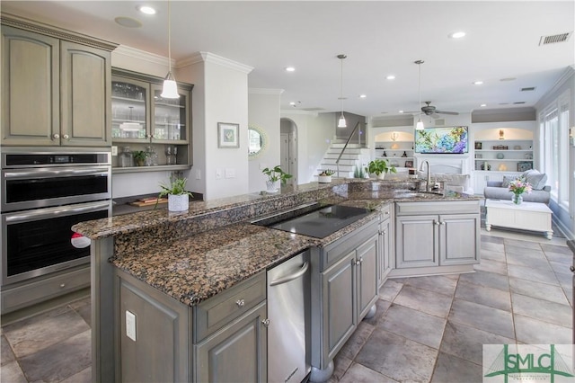 kitchen featuring ceiling fan, visible vents, open floor plan, ornamental molding, and stainless steel appliances