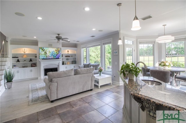 living area featuring ornamental molding, recessed lighting, and ceiling fan