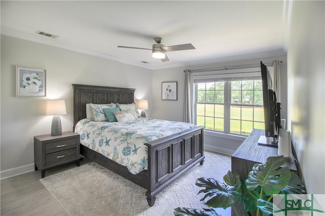bedroom featuring baseboards, light wood-style flooring, crown molding, and visible vents