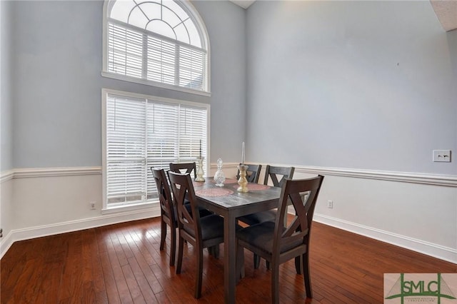 dining area with wood-type flooring and baseboards