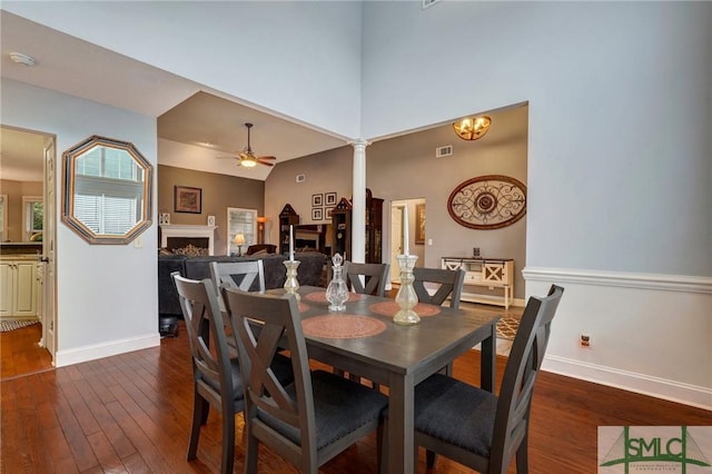 dining area featuring visible vents, decorative columns, baseboards, ceiling fan, and dark wood-style floors