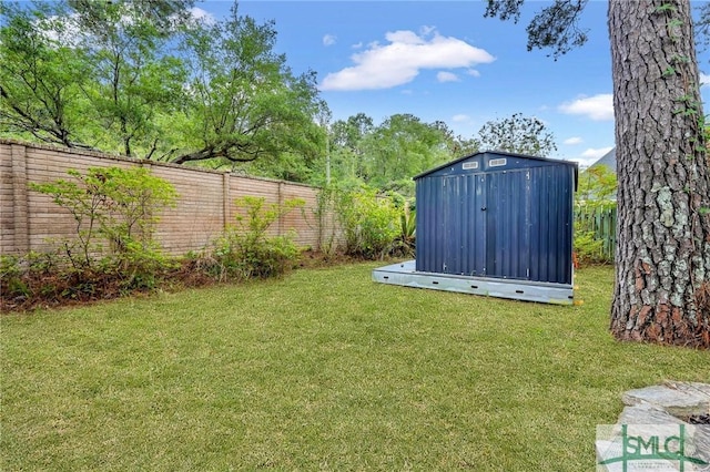 view of yard featuring a storage shed, fence, and an outdoor structure
