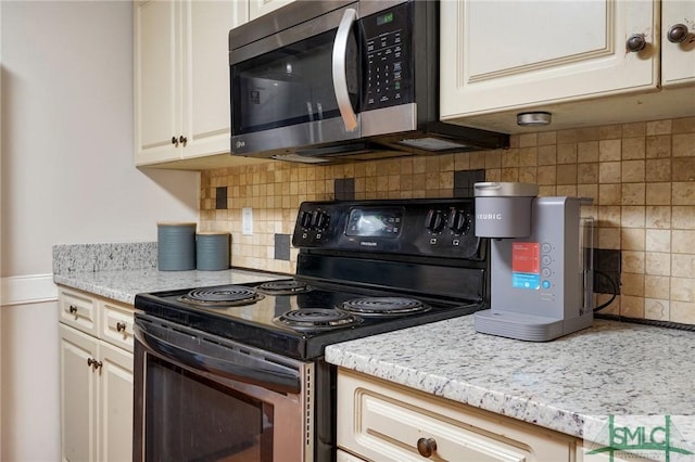 kitchen with decorative backsplash, light stone countertops, and stainless steel appliances