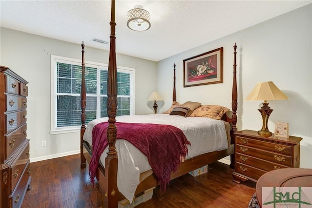 bedroom featuring baseboards, visible vents, and wood finished floors