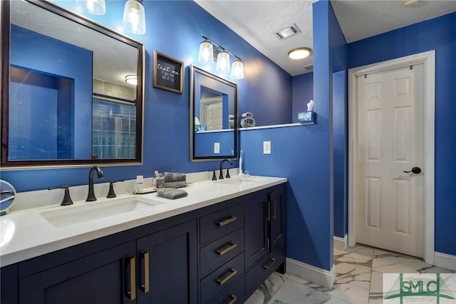 bathroom with a sink, baseboards, a textured ceiling, and marble finish floor