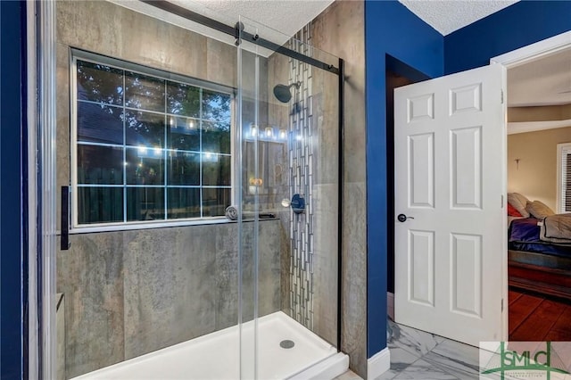 ensuite bathroom with ensuite bathroom, a shower stall, a textured ceiling, and marble finish floor
