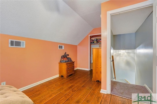 bonus room with baseboards, visible vents, wood finished floors, and lofted ceiling