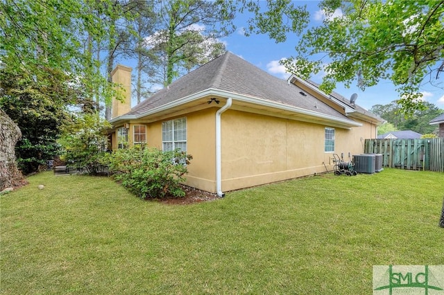 view of property exterior featuring a chimney, a lawn, central AC unit, fence, and stucco siding