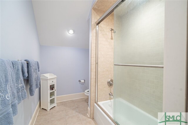 full bathroom featuring bath / shower combo with glass door, tile patterned floors, baseboards, and toilet