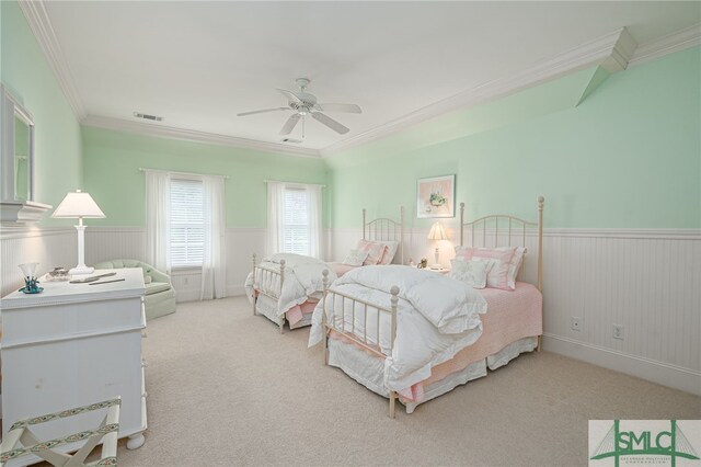 carpeted bedroom featuring crown molding, visible vents, and a wainscoted wall