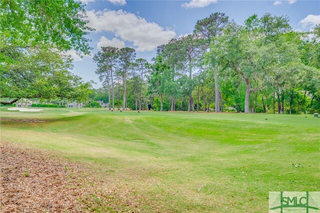 view of property's community with a lawn and view of golf course