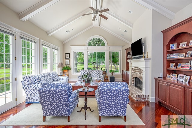 living room featuring beamed ceiling, a ceiling fan, a brick fireplace, and dark wood finished floors