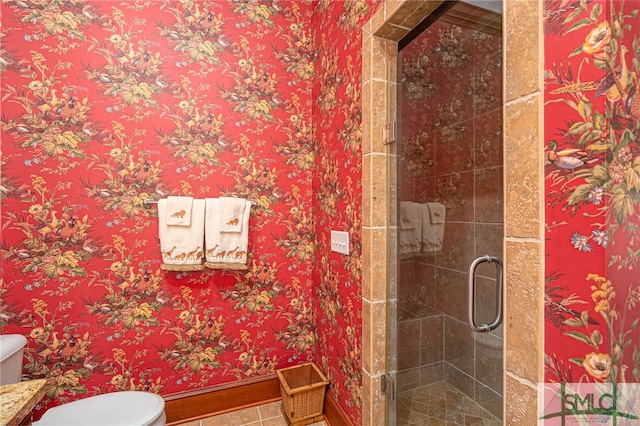 bathroom featuring baseboards, tile patterned flooring, a shower stall, and toilet