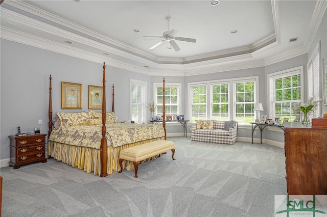 bedroom with baseboards, ornamental molding, a tray ceiling, and carpet