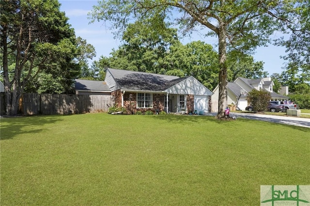 121 Pelican Ln, Richmond Hill, GA 31324 - view of front of home with fence, brick siding, a garage, a front yard, and concrete driveway