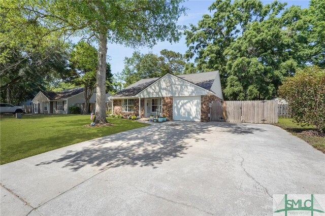 121 Pelican Ln, Richmond Hill, GA 31324 - english style home with fence, a front lawn, brick siding, a garage, and driveway
