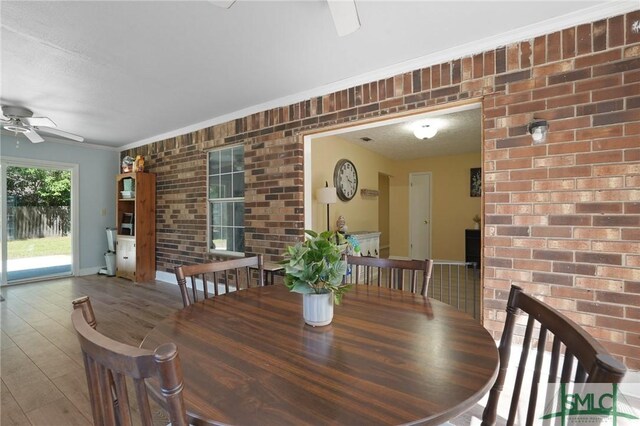 121 Pelican Ln, Richmond Hill, GA 31324 - dining room featuring ceiling fan, brick wall, crown molding, wood finished floors, and baseboards