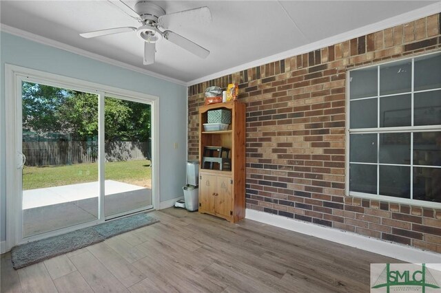 121 Pelican Ln, Richmond Hill, GA 31324 - interior space with crown molding, wood finished floors, brick wall, baseboards, and a ceiling fan